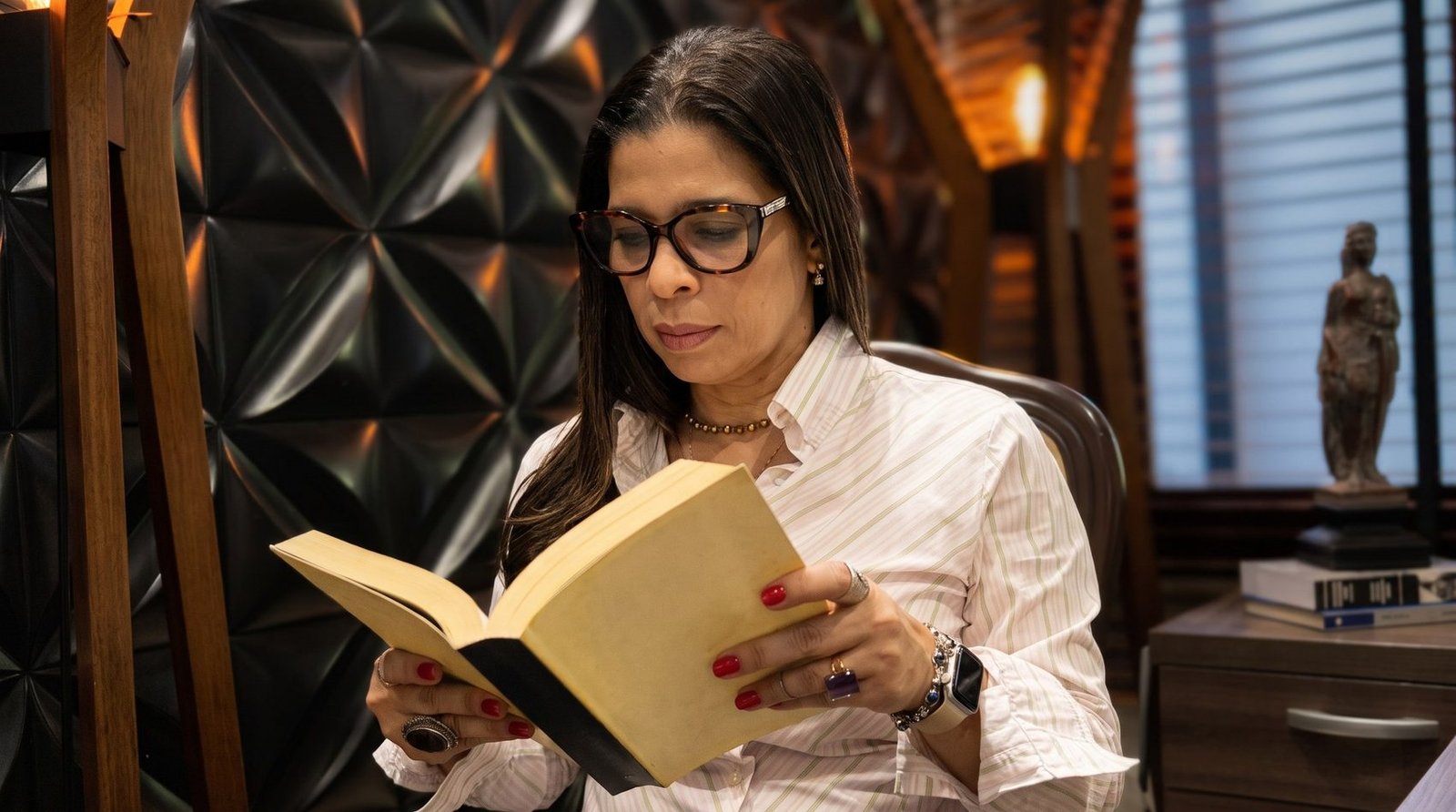 Carla Bianchi Mendes lendo no escritório